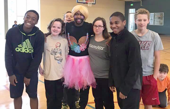 Coach Avery, wearing a pink tutu, surrounded by students.